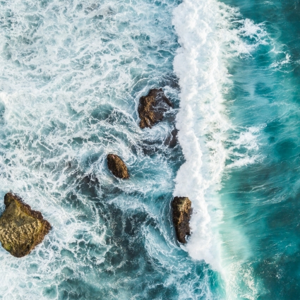 Aerial view of crashing waves on rocks. View from above, drone photo, beautiful nature background