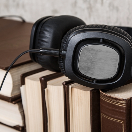 Audiobooks concept. Old books and black headphones