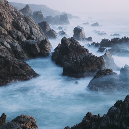 The Pacific Ocean coastline, with waves crashing against the shore.
