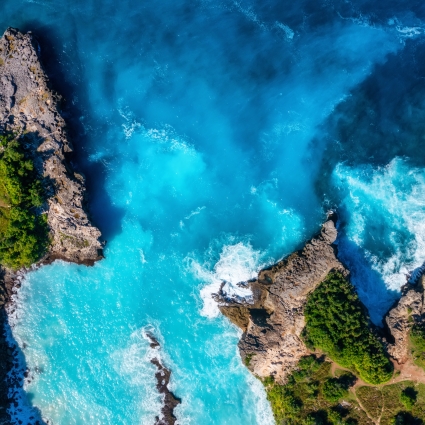 Waves and rocks as a background from top view. Blue water background from top view. Summer seascape from air. Bali island, Indonesia.