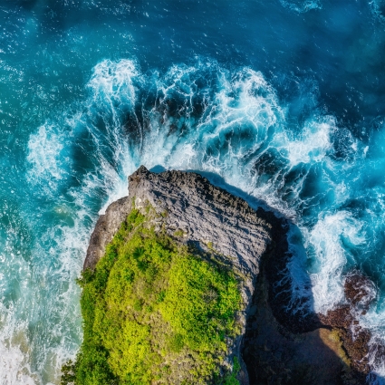 Waves and rocks as a background from top view. Blue water background from top view. Summer seascape from air.